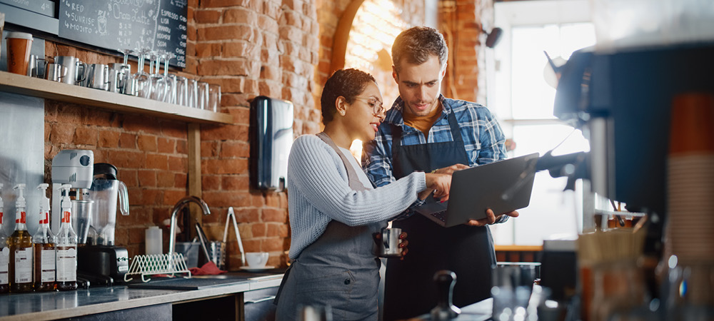 Operating Lines of Credit - Rivers Edge Bank business owners pointing at and looking at a laptop screen.