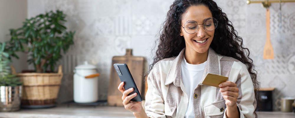 woman-holding-debit-card-and-phone