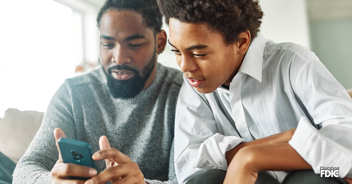 financial-literacy-for-kids father-showing-son-money-tips-on-phone