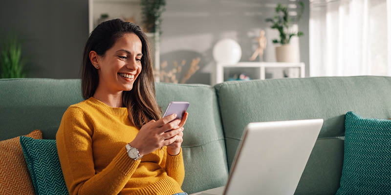 woman-yellow-sweater-on-phone